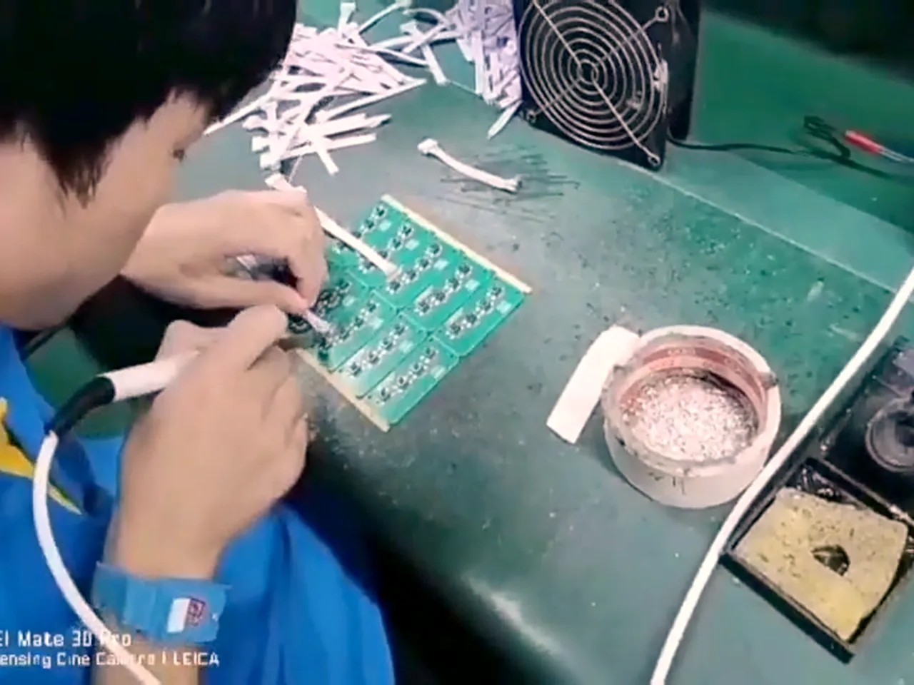 Technician hand-soldering a board for rework